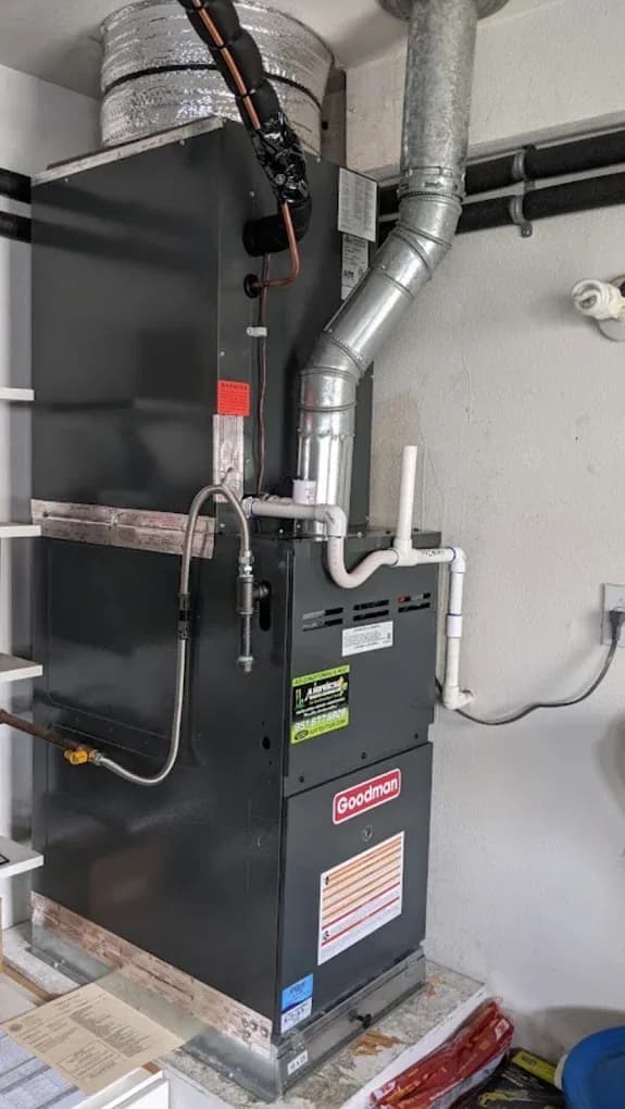 An open residential gas furnace cabinet with its flue venting above it