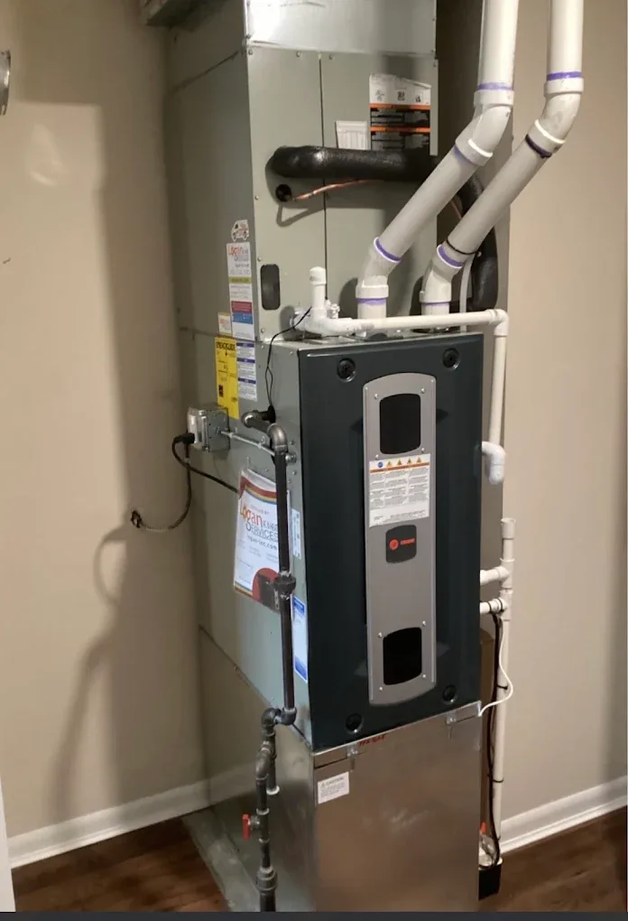 A high-efficiency gas furnace and its PVC flue venting installed in a home utility closet